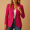 Femme portant le blazer cintré rose ouvert sur un top blanc et un jean