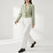 Blazer court vert porté avec un pantalon blanc et des mocassins
