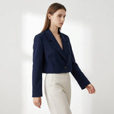 Blazer court bleu marine porté avec un pantalon clair
