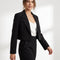 Blazer court noir à revers porté avec un pantalon noir