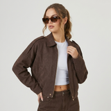 Blouson court marron porté avec des lunettes de soleil