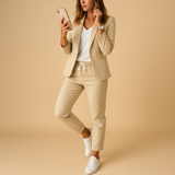 Ensemble blazer et pantalon beige porté avec des baskets blanches