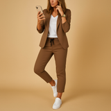 Ensemble blazer et pantalon marron porté avec des baskets blanches