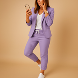 Ensemble blazer et pantalon violet porté avec des baskets blanches
