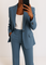 Détail du blazer bleu et du pantalon large assorti