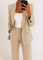 Détail du blazer beige et du pantalon assorti