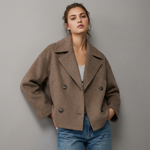 Manteau court croisé marron porté avec un jean