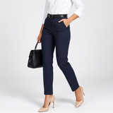 Pantalon taille haute bleu marine porté avec un sac à main