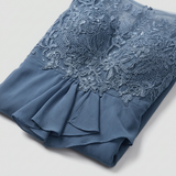 Détail de la dentelle et du tissu fluide de la robe bleue